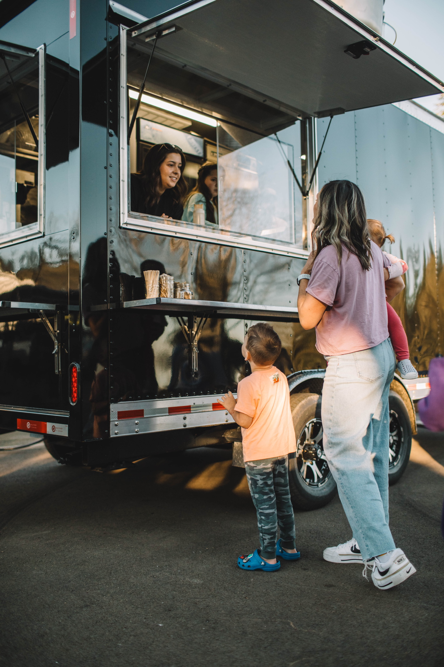 A family ordering from the Bub's Mini Donuts trailer window