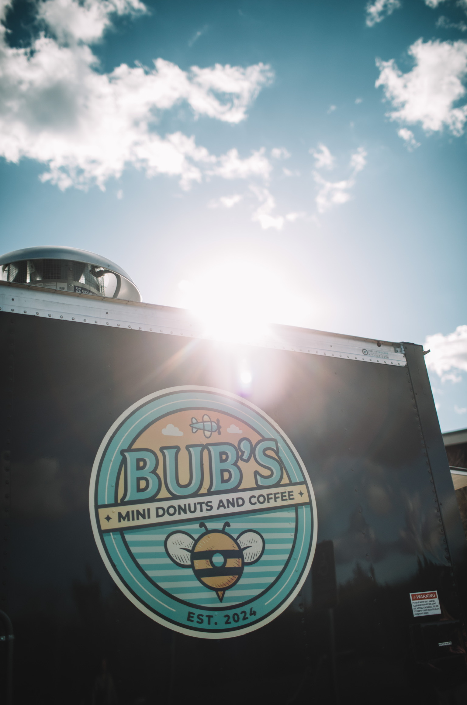 Sunlight shining over the Bub's Mini Donuts and Coffee logo