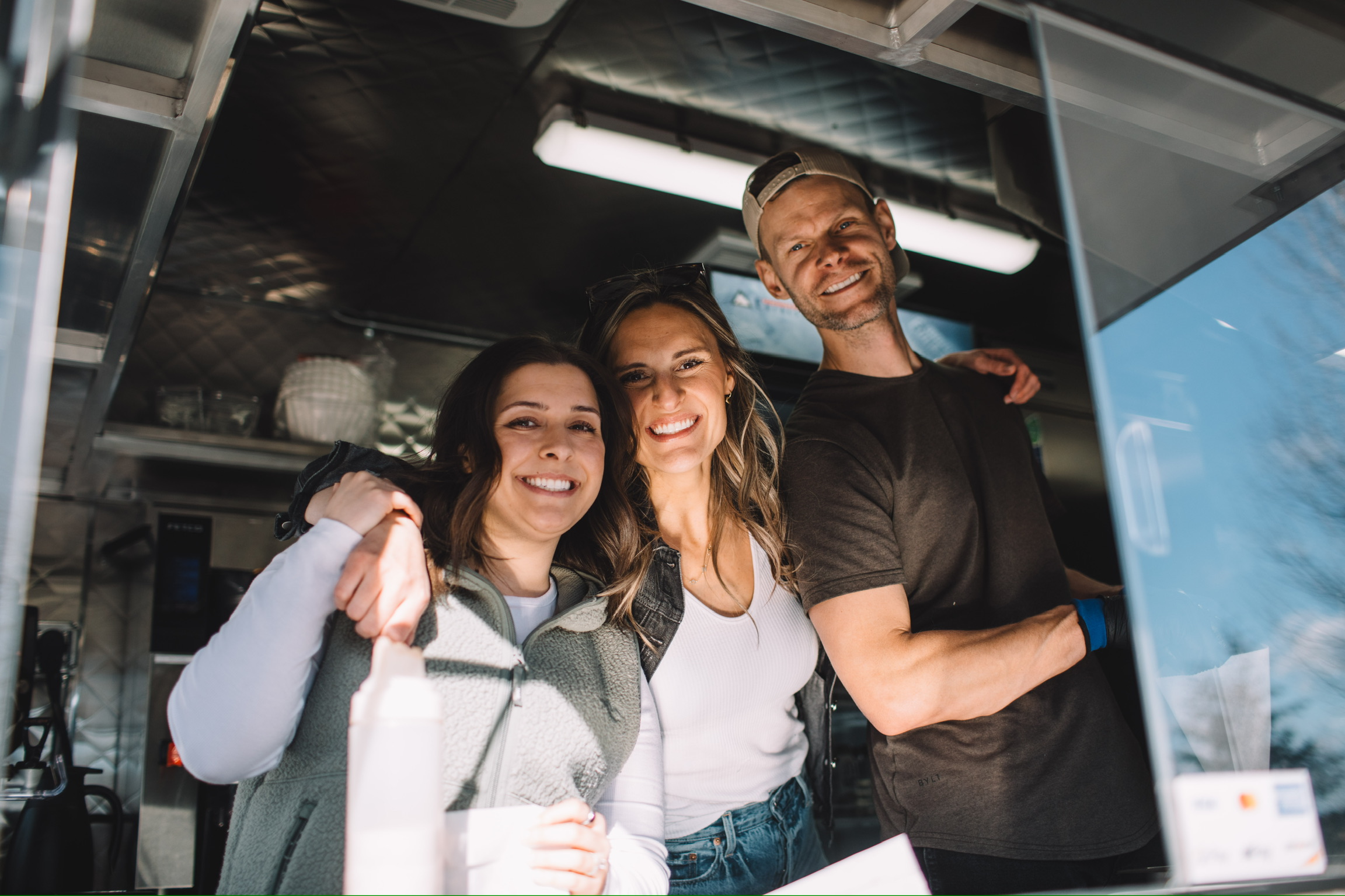 The smiling Bub's team together inside the food trailer