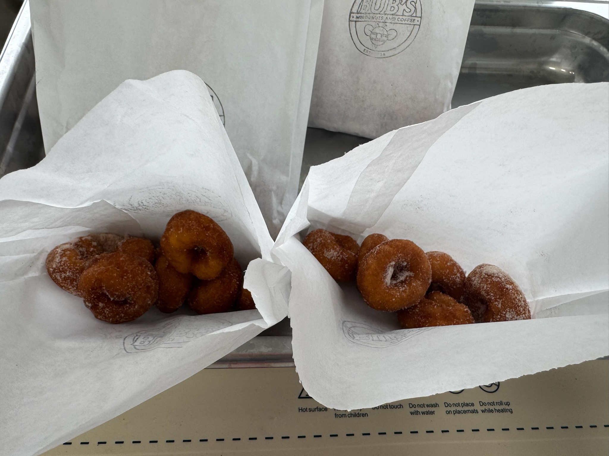 Warm cinnamon sugar mini donuts served in Bub's paper bags