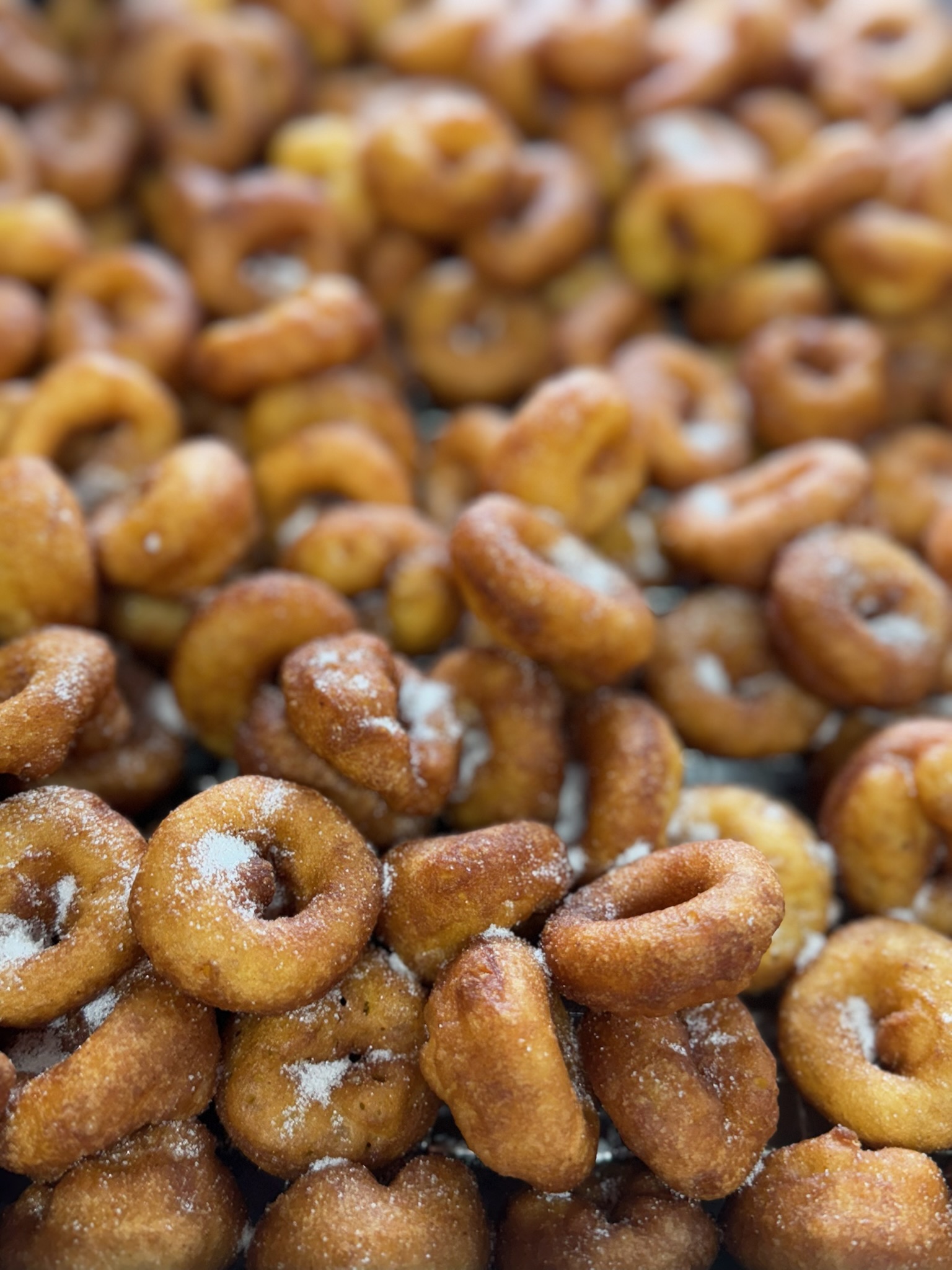 A fresh batch of warm mini donuts dusted with cinnamon sugar